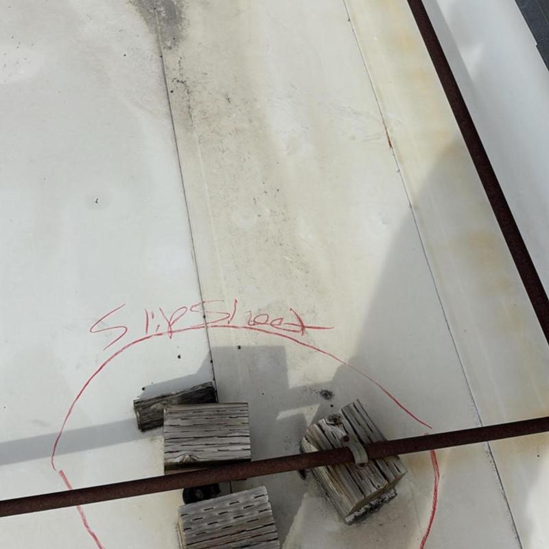 TPO roof with damaged wood blocks and rusty pipe