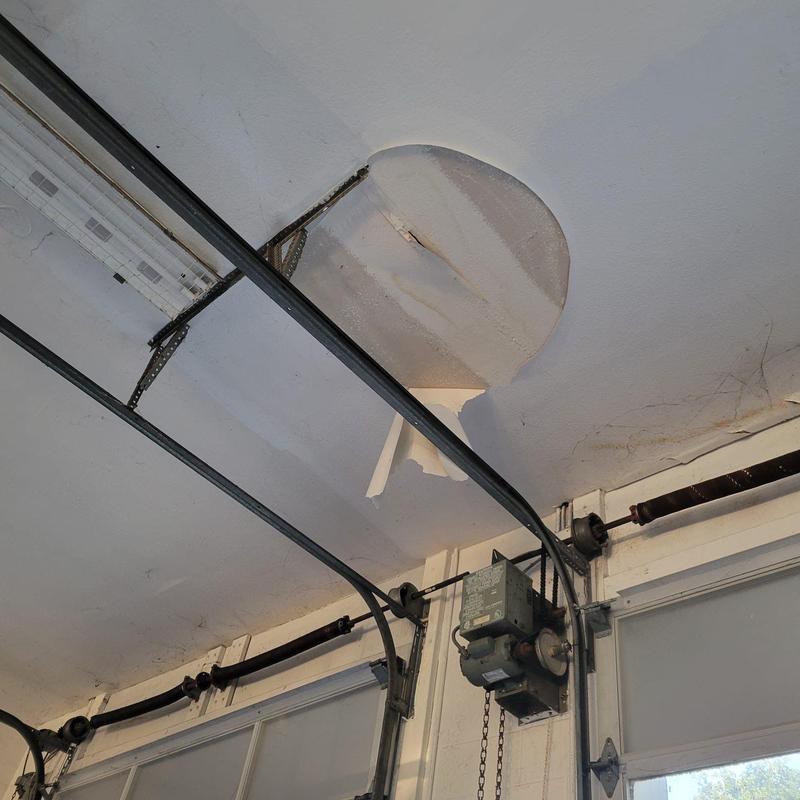Garage door opener motor with damaged ceiling panel