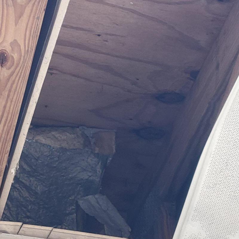 Roof plywood with water stains and damage inside attic