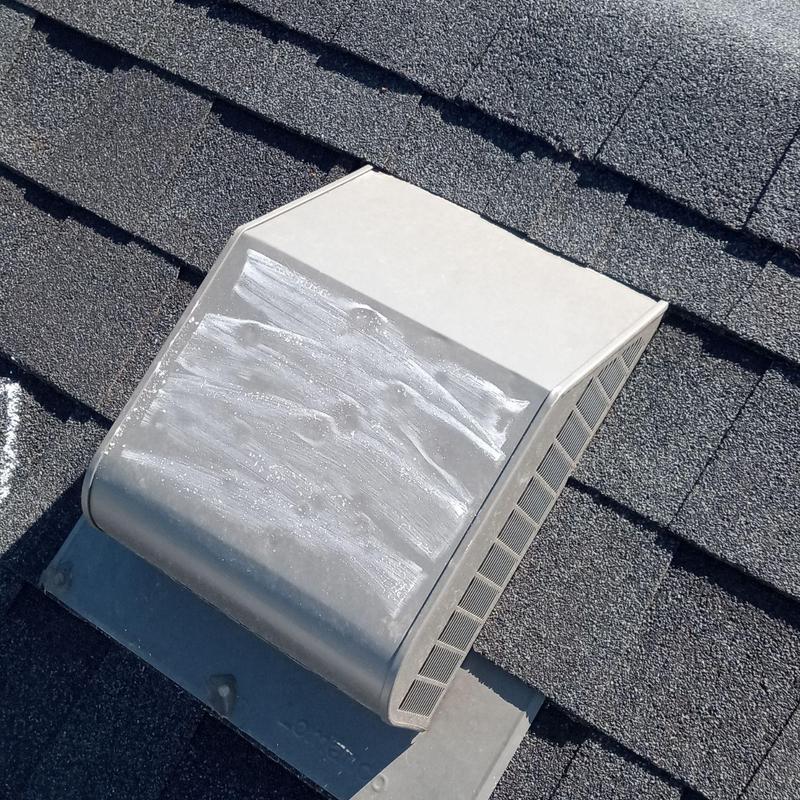Roof vent with hail impact marks on shingles