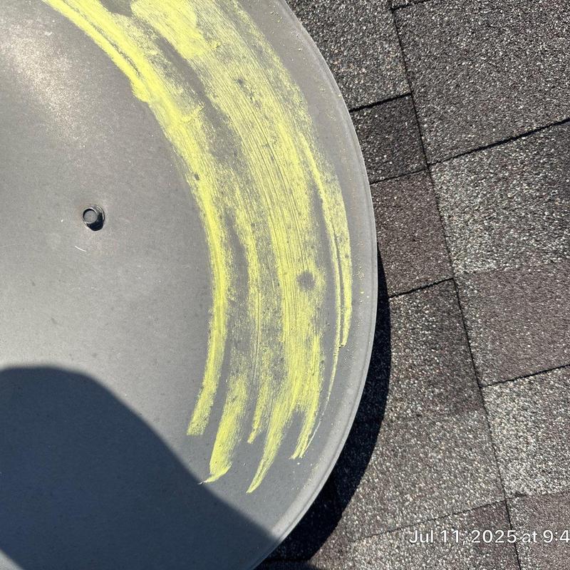 Satellite dish surface wear with yellow marking on roof shingles