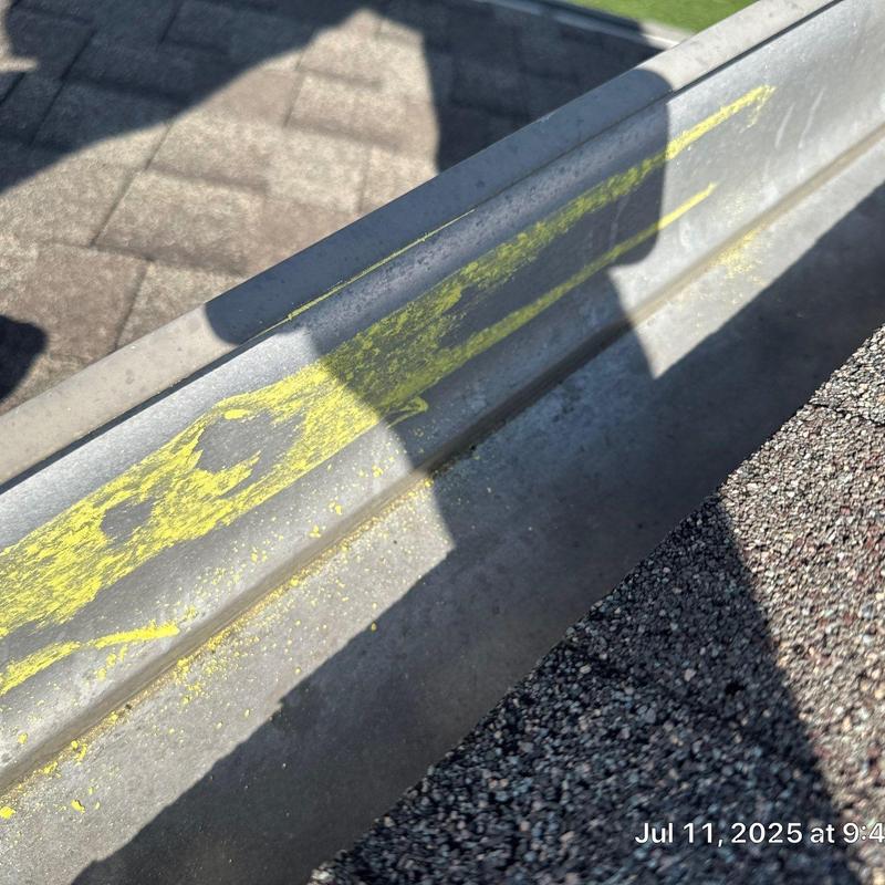 Metal roof gutter with hail damage and chalk markings