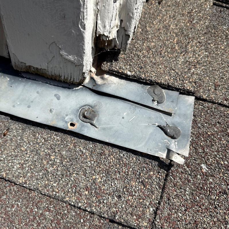 Roof flashing with nails and cracked wood trim damage