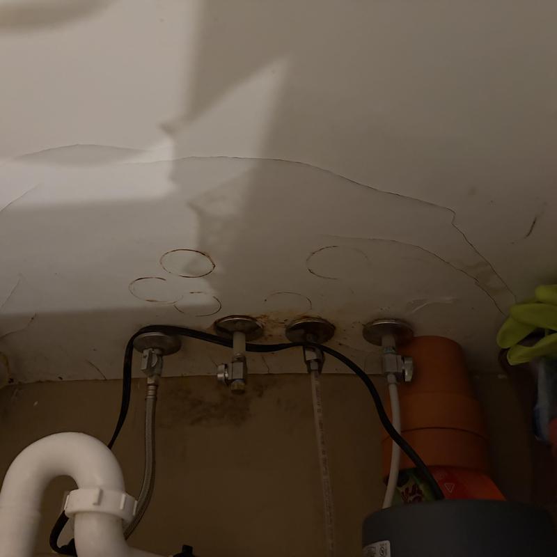 Water supply lines under kitchen sink with wall stains Water supply lines under kitchen sink with wall stains