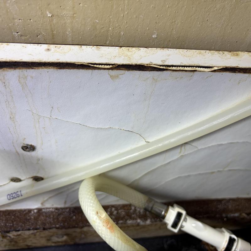 Faucet supply line with rust stains and wall damage Faucet supply line with rust stains and wall damage