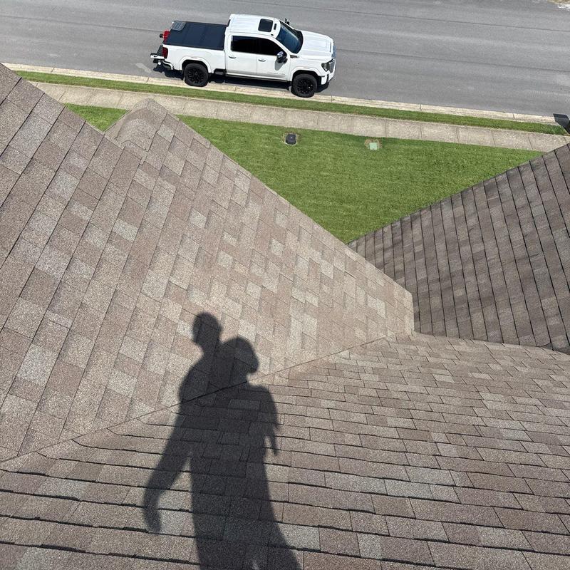 Asphalt shingle roof with shadow and nearby white truck