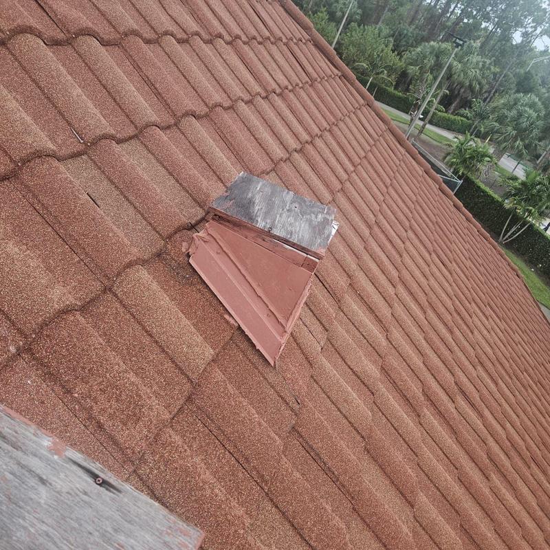 Stonecoated steel roof with damaged panels near vent