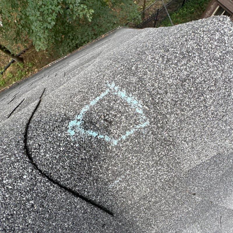 Asphalt shingle roof with hail damage marked for repair