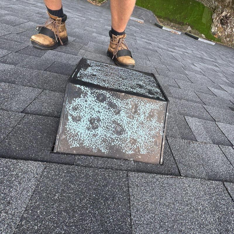 Roof shingles around metal vent showing hail damage