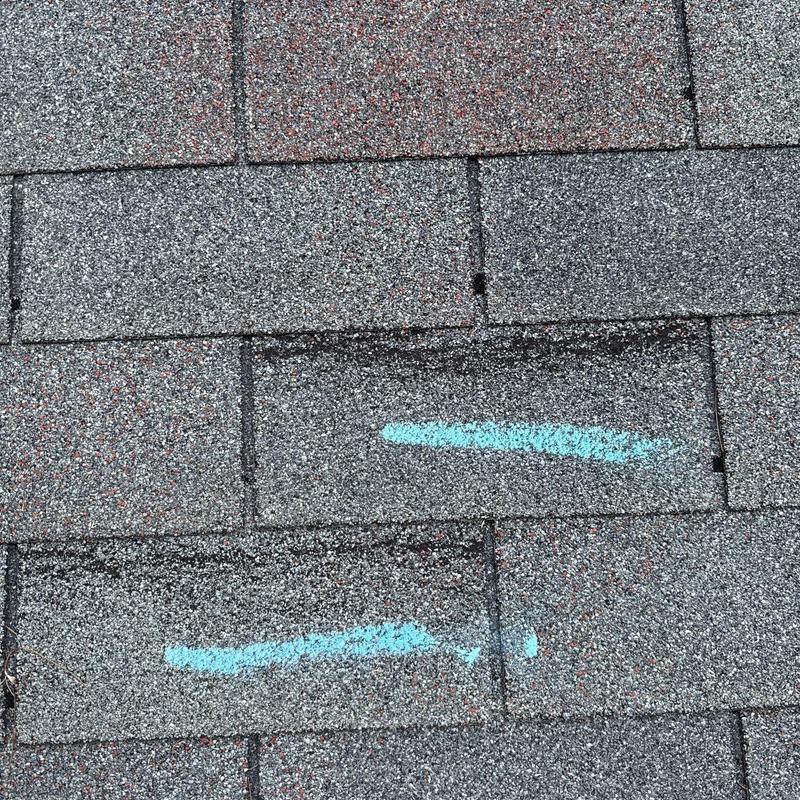 Asphalt shingles with marked hail damage on roof