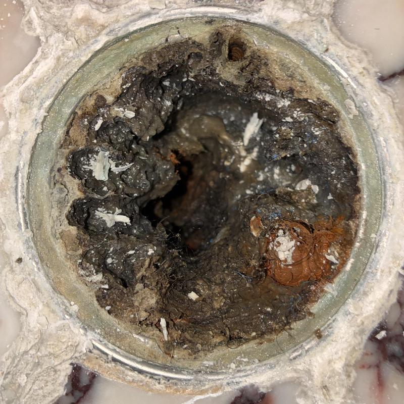 Clogged shower drain buildup before cleaning