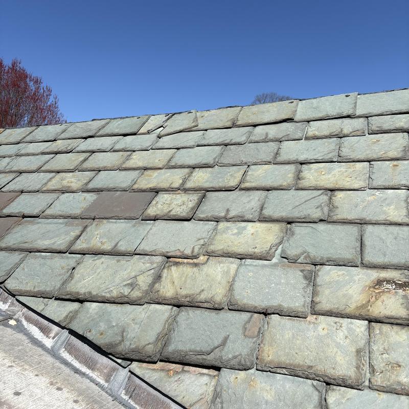Slate roof tiles showing wear and damage signs Slate roof tiles showing wear and damage signs