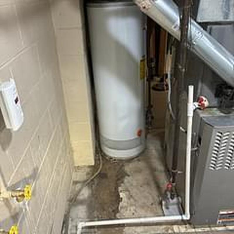 Water heater with floor water leak and nearby furnace system