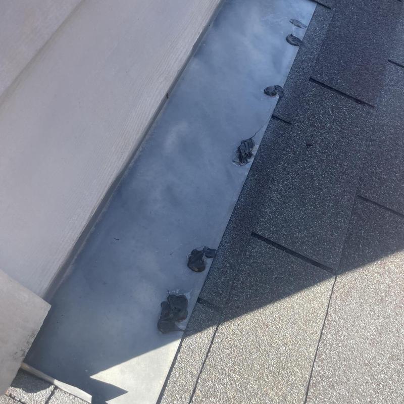 Metal roof flashing along wall with sealant spots