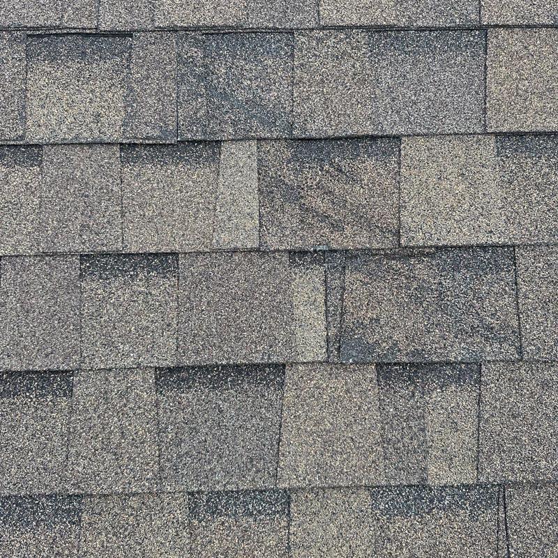 Asphalt roof shingles with visible hail damage and wear