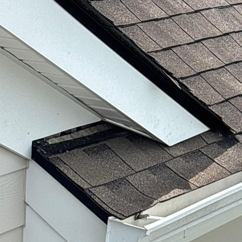 Asphalt shingle roof with hail damage near gutter edge