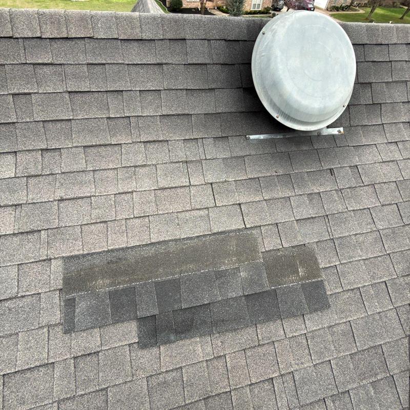 Asphalt roof shingles with patched hail damage near vent