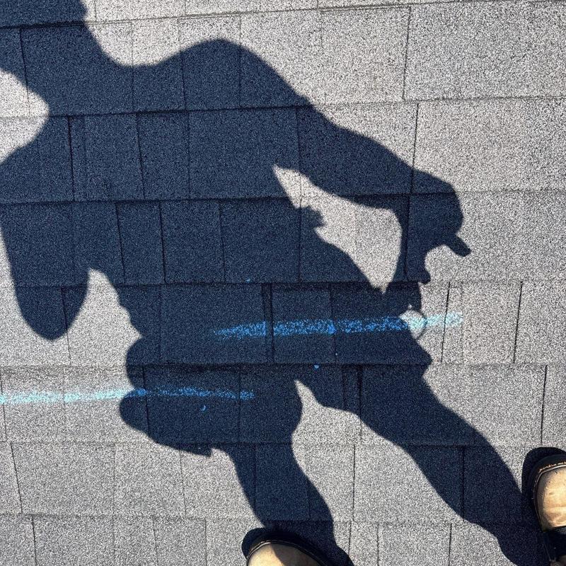 Asphalt shingles with hail damage markings on roof