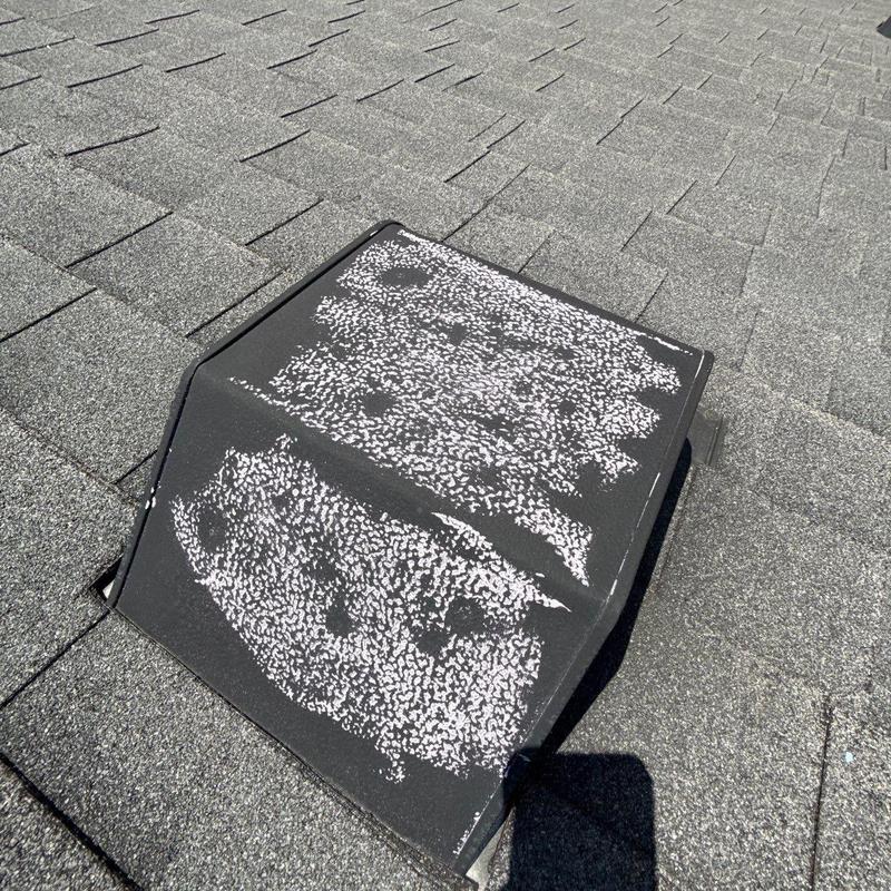 Roof vent with hail damage on shingle roof