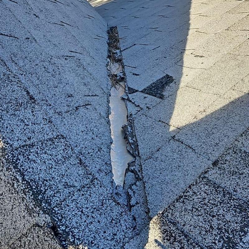 Shingle roof with damaged ridge and missing granules
