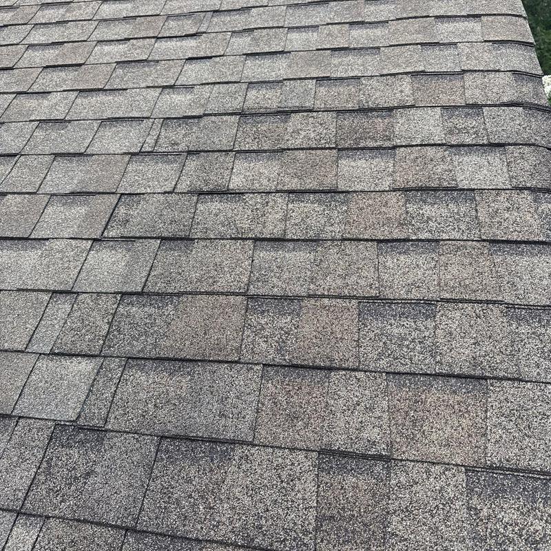 Asphalt roof shingles with visible hail damage