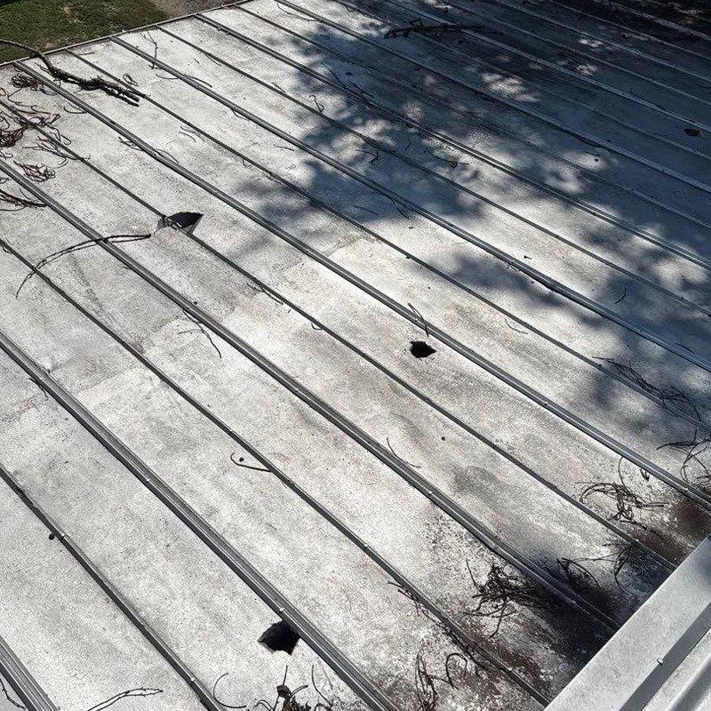 Metal commercial roofing panels with hail damage holes