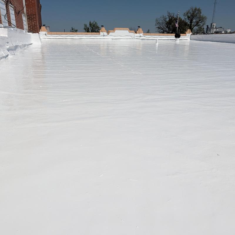 Elastomeric flat roof restoration coating on commercial building