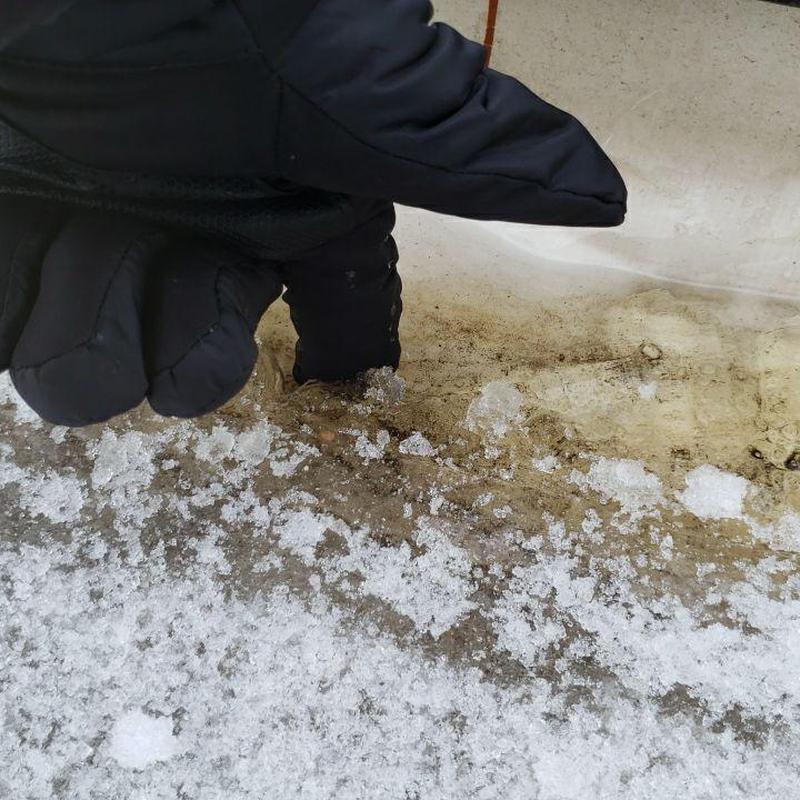 TPO flat roof seam with snow and glove inspection