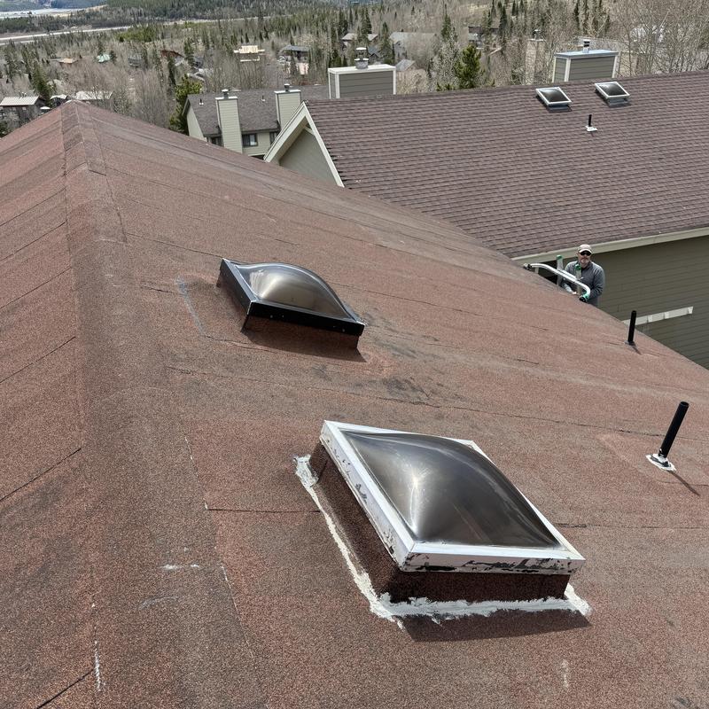 Skylight roof sealing with visible caulking on shingles