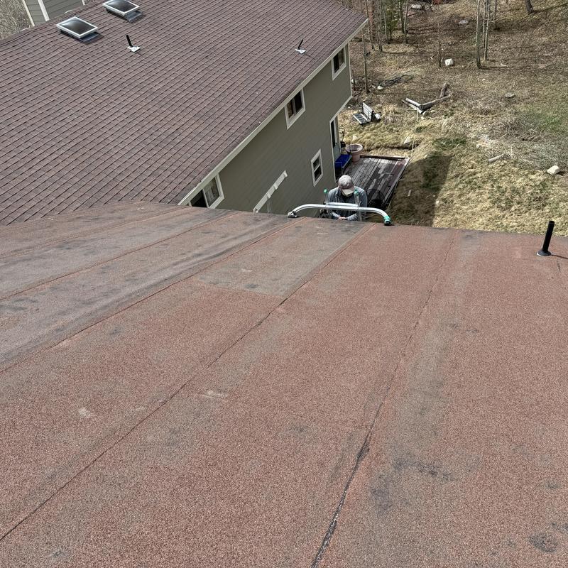 Flat roof surface with visible seam and worker below