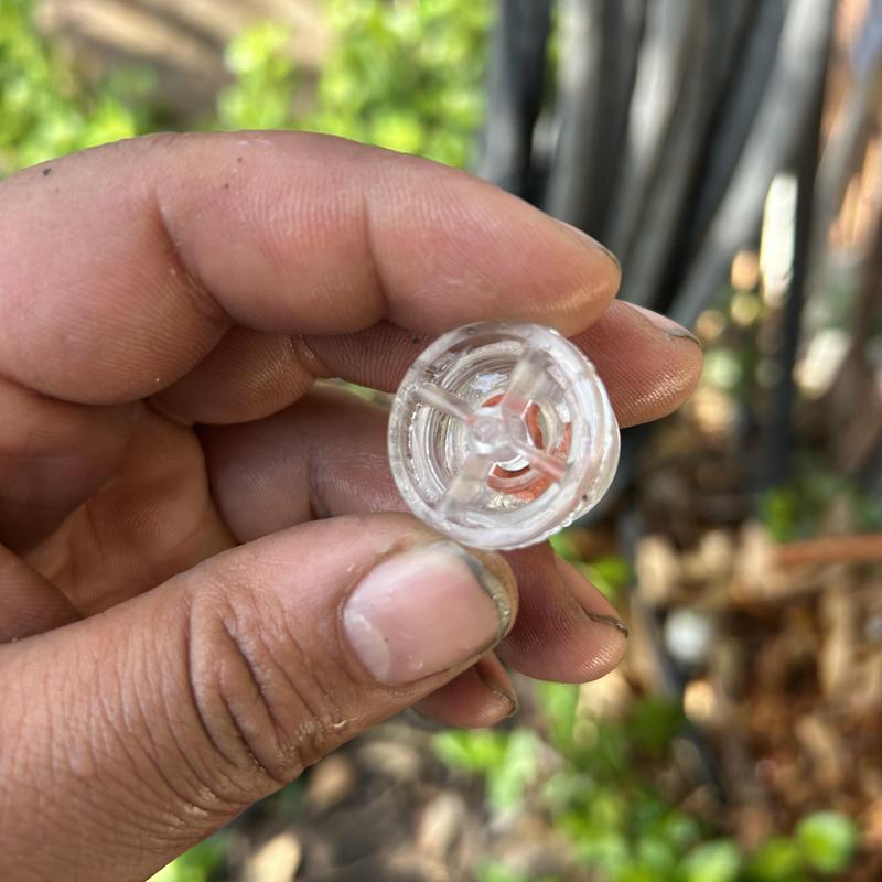 Hose bib gasket held between fingers showing wear