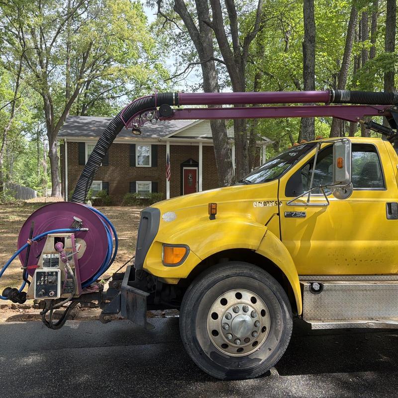 Vacuum hose and reel on yellow Vac truck
