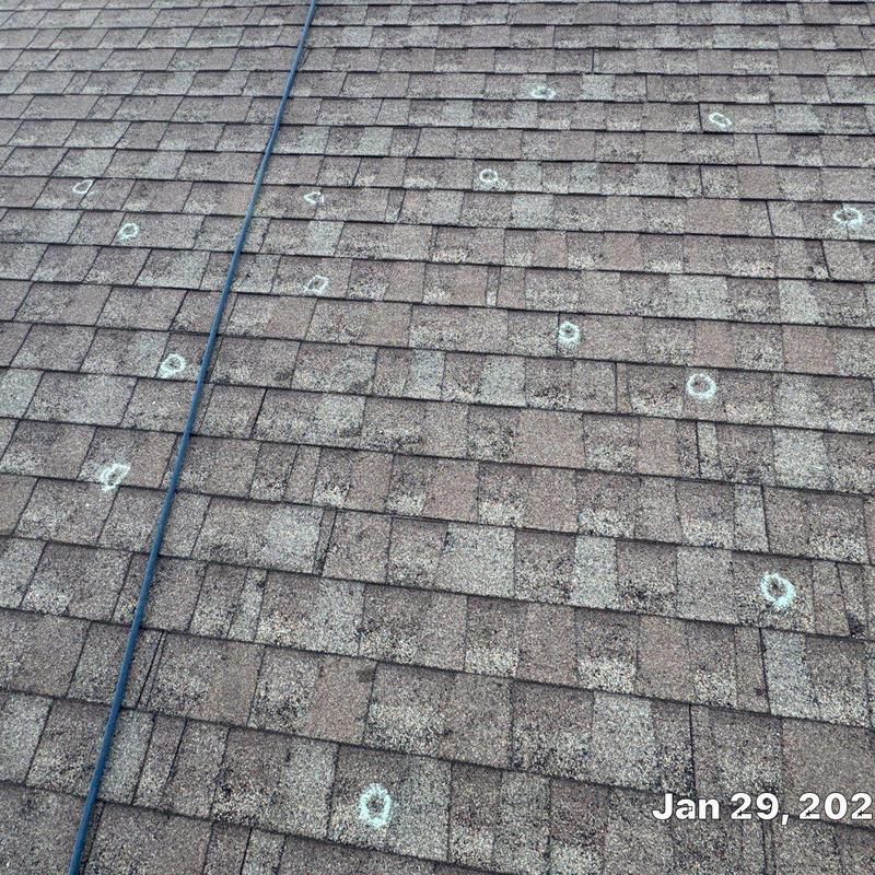 Asphalt shingle roof with hail damage marked for repair