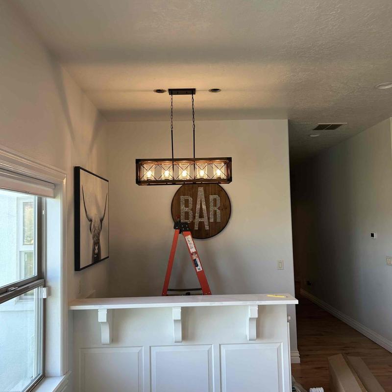 Bar light fixture installation above home bar area