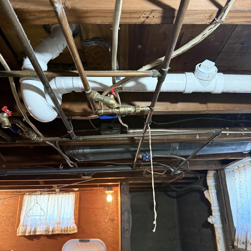 PVC drainage pipe and copper water supply lines in basement ceiling
