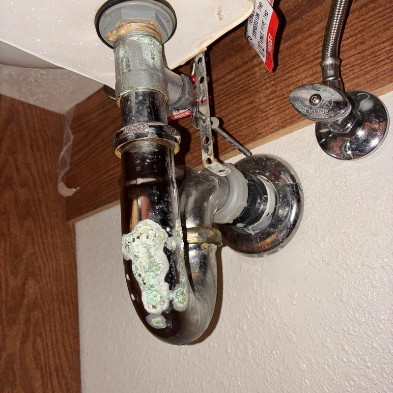 Kitchen sink P-trap with corrosion buildup under sink
