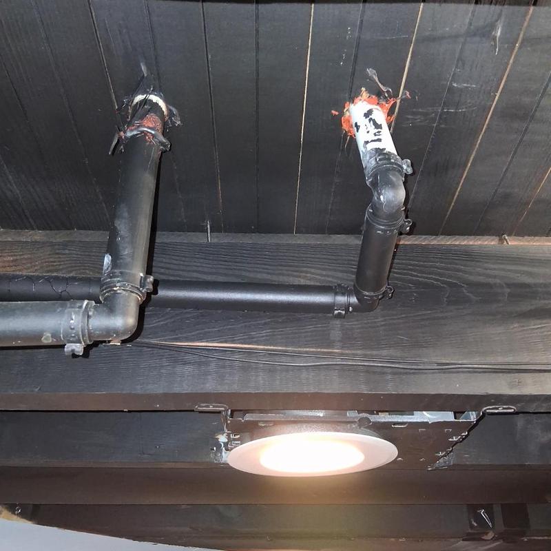Black cast iron drain pipes with ceiling light above
