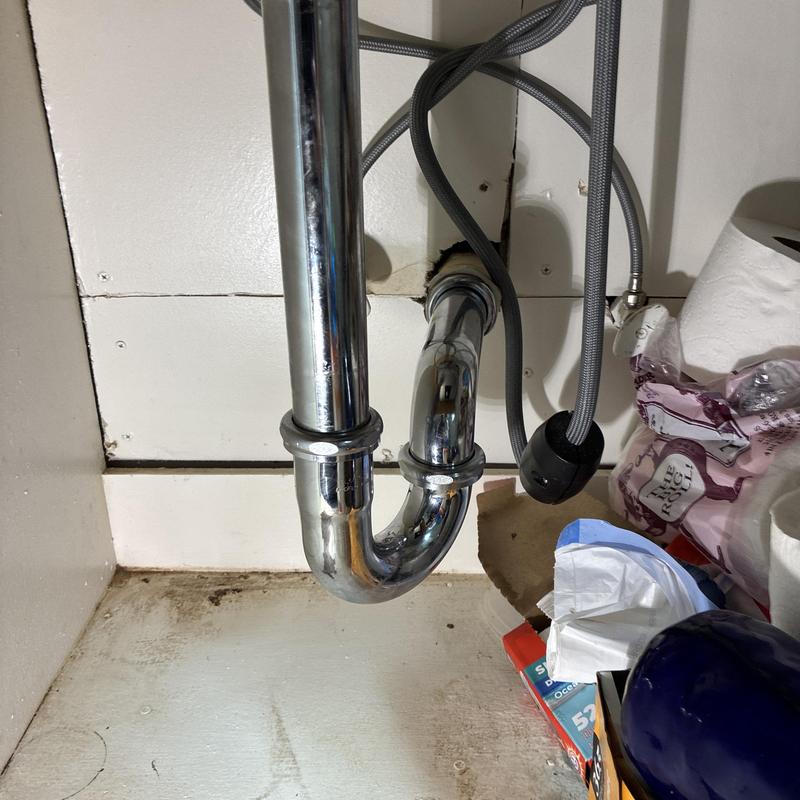 Kitchen sink P-trap with repaired leak under cabinet