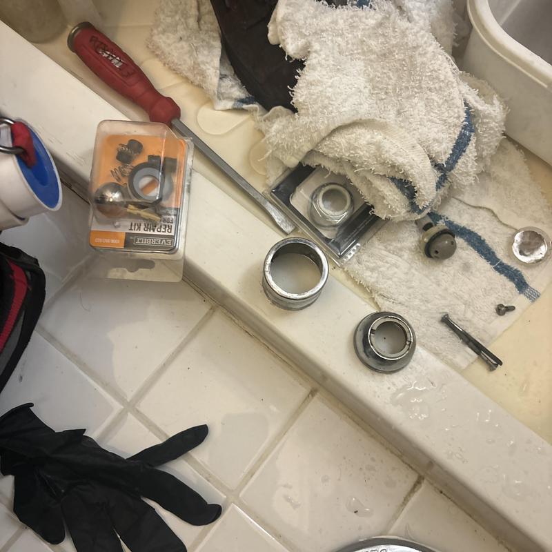 Shower valve parts and tools on bathroom counter