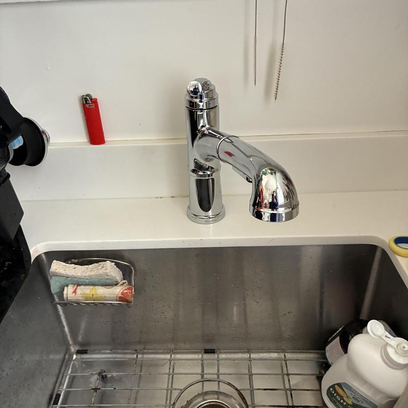 Kitchen faucet installed above stainless steel sink