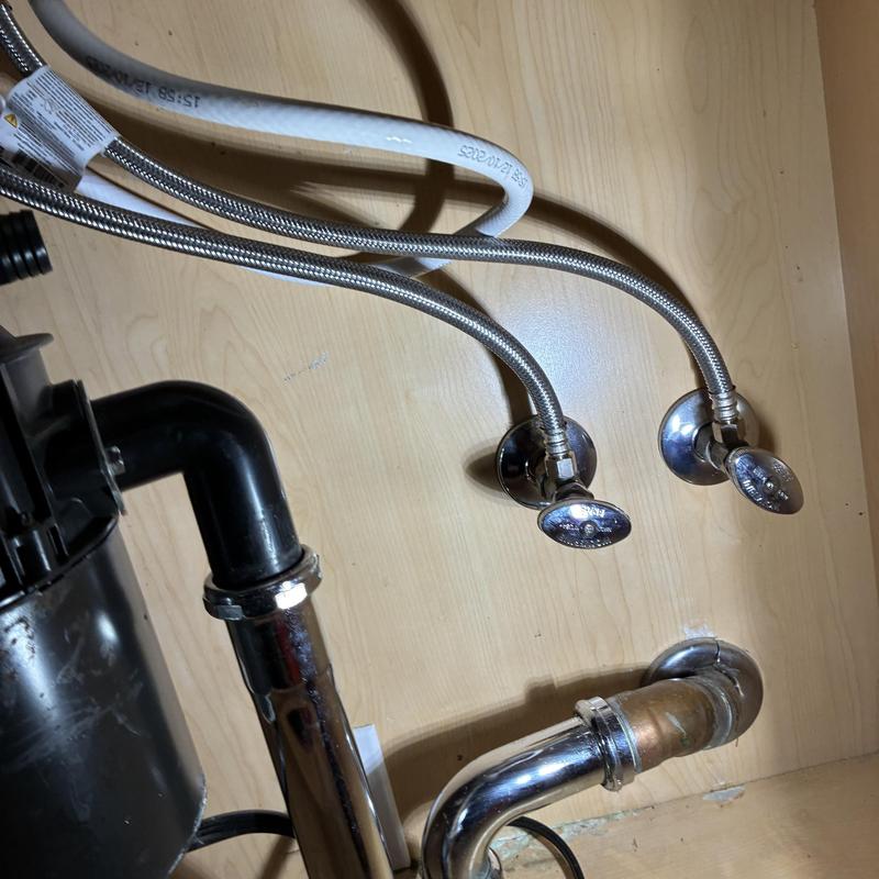 Kitchen faucet supply lines and drain pipes under sink