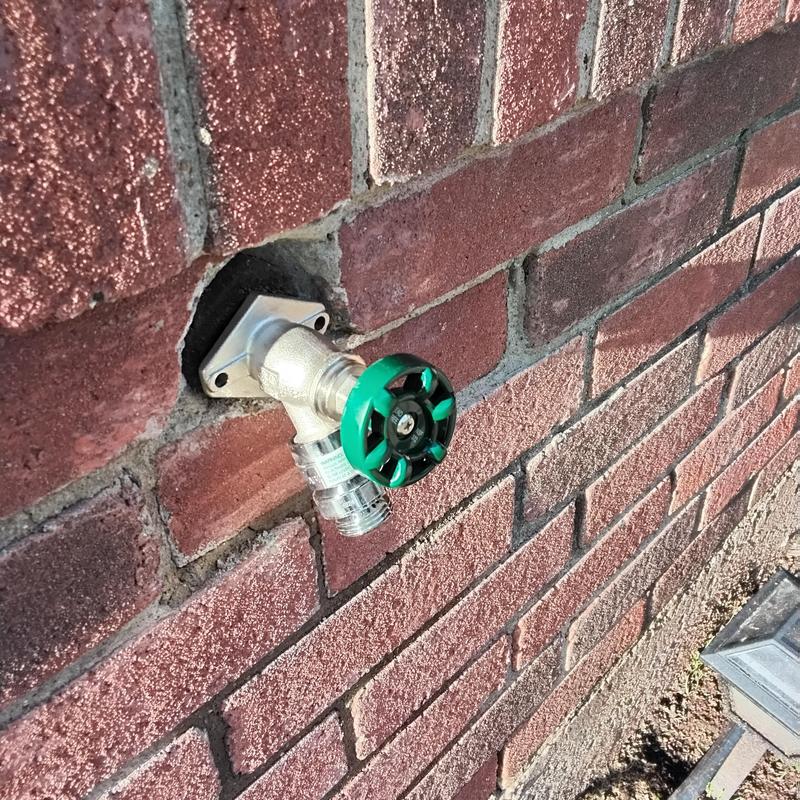 Exterior hose bib installation on brick wall
