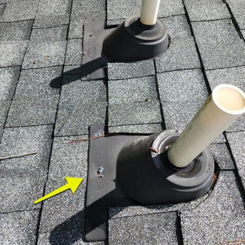 Dryer roof vent flashing on shingle roof with yellow arrow