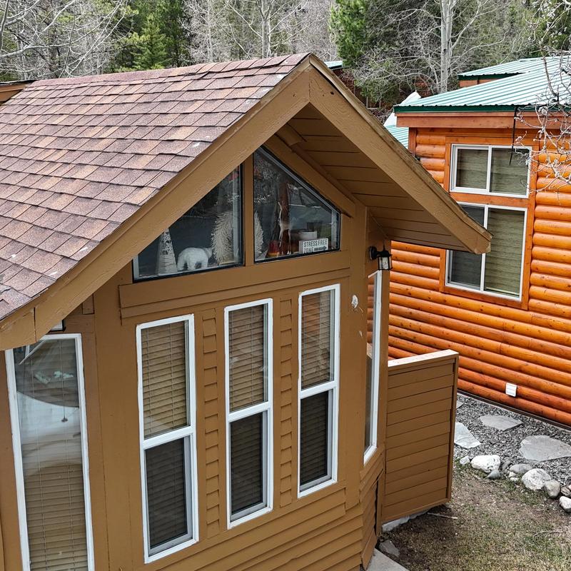 Asphalt shingle roof on cabin with triangular windows