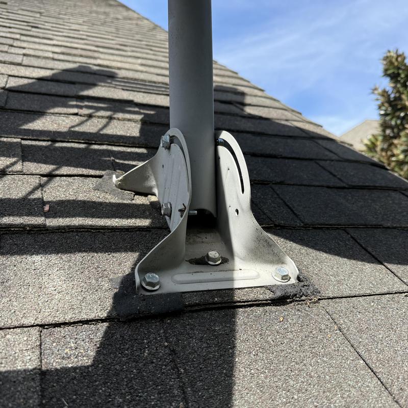 Satellite dish mount on shingled roof with sealed base