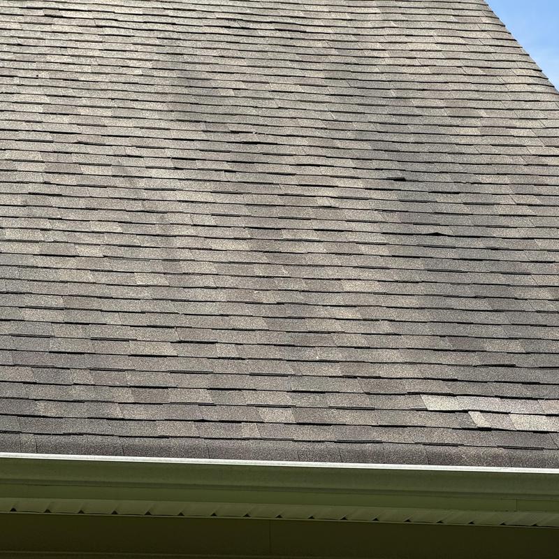 Asphalt roof shingles with nail damage and wear