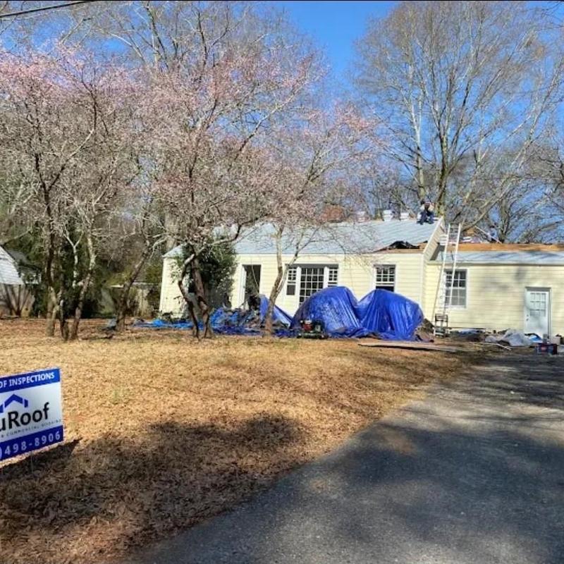 Asphalt shingle roof replacement with tarps on house