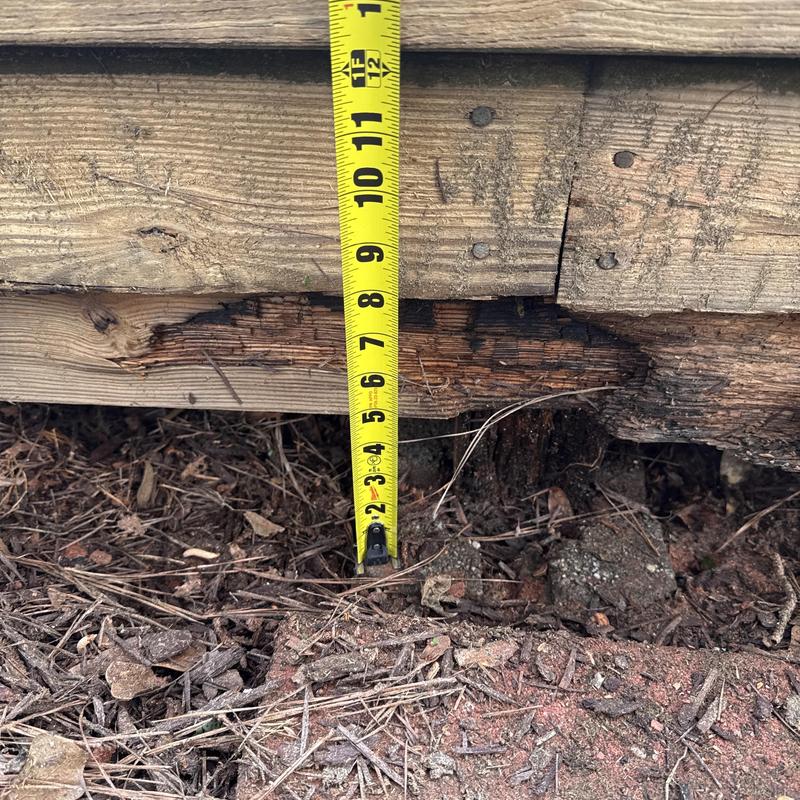 Rotten deck support post with measuring tape