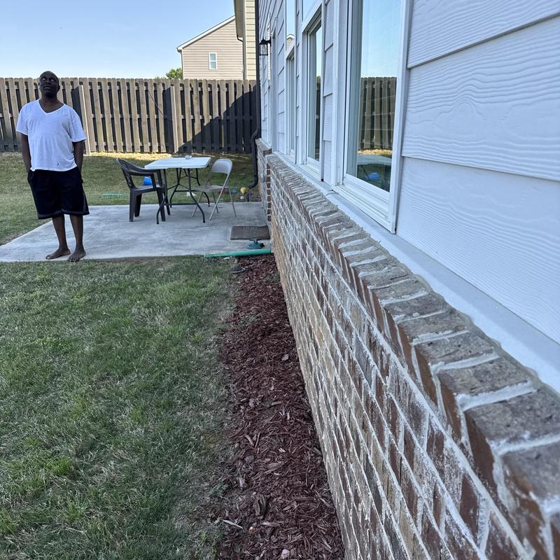 Concrete pad with outdoor chairs and table in backyard