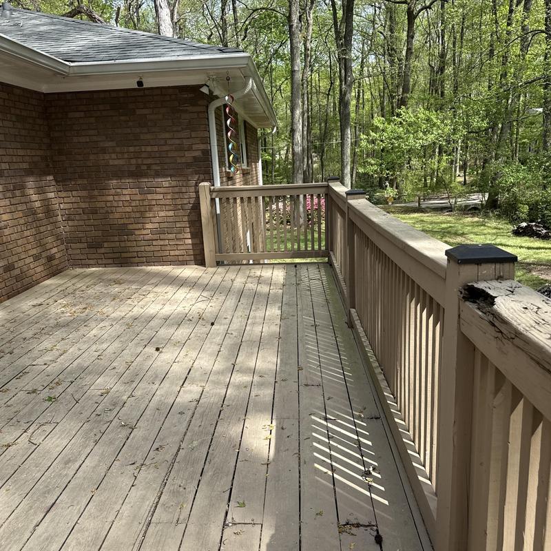 Wooden deck with railing and gate in backyard
